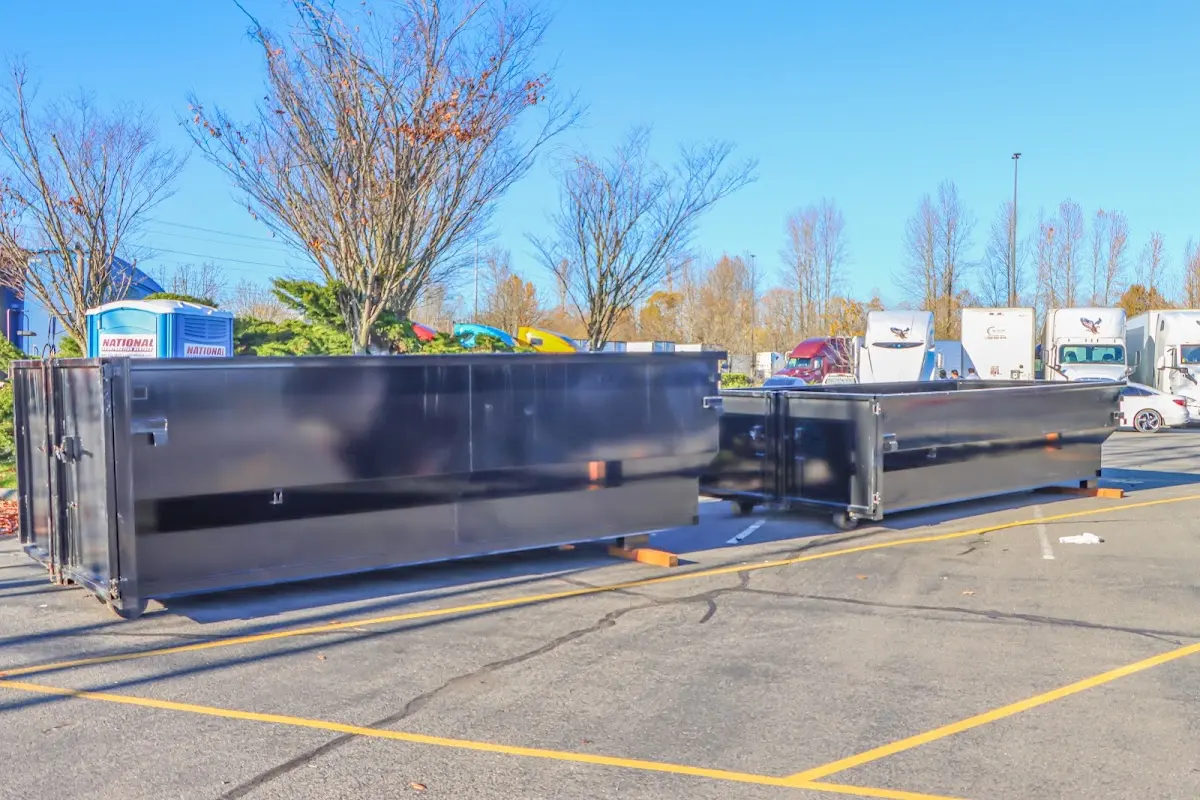 Professional dumpster rental service with roll-off container on residential driveway in Green Oak